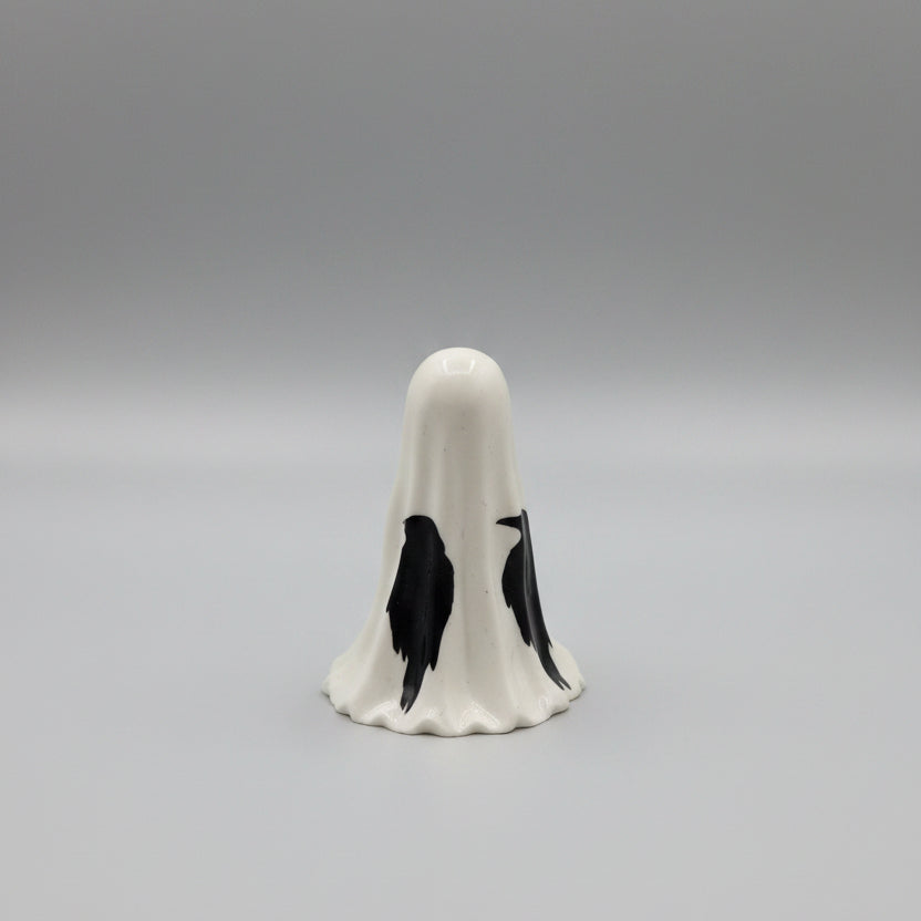 Small gothic ghost ornament with raven decals displayed on a shelf in spooky home décor setting