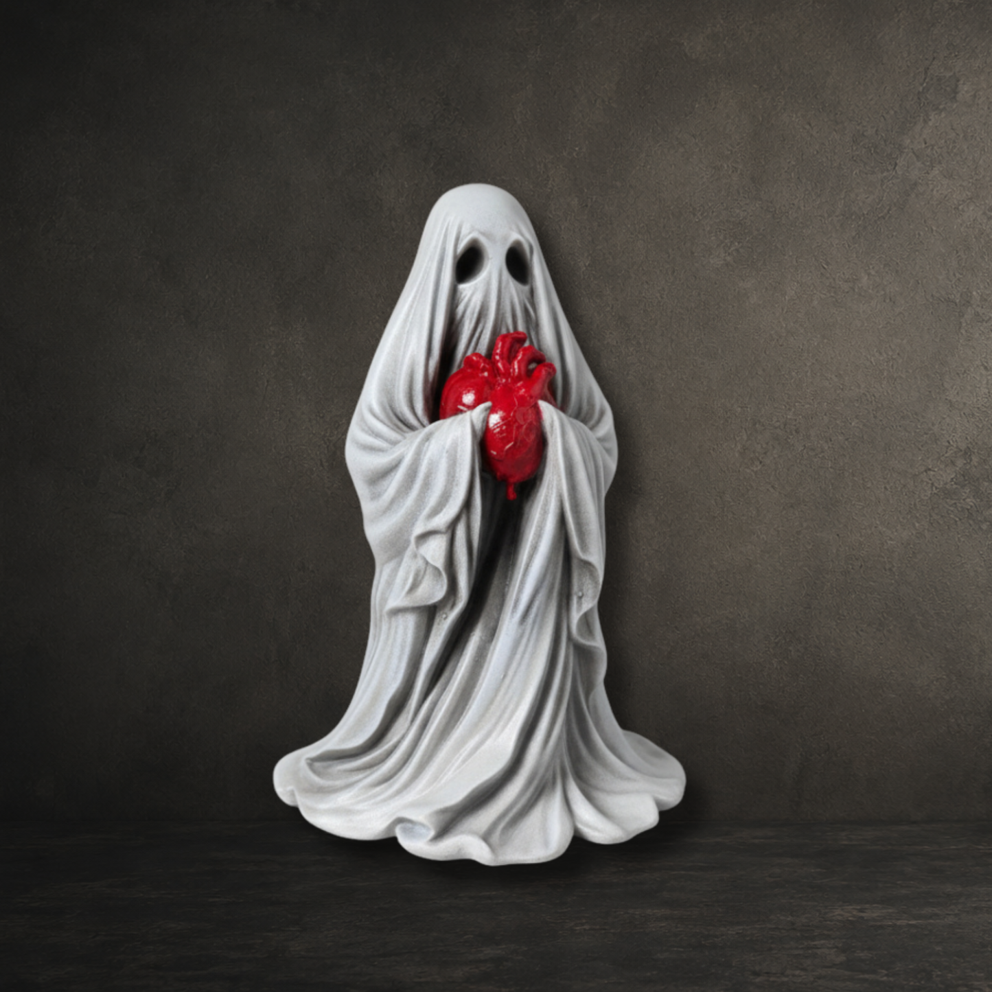 Hand painted resin ghost holding an anatomical heart, perfect for gothic home décor and dark curiosity collections.