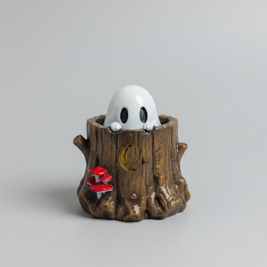 Hollis Moonwisp Ghost peeking from a woodland tree stump with red mushrooms.