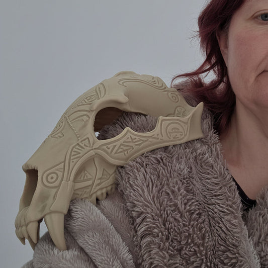 Front angled view of a gothic bear skull pauldron with carved rune detailing and oversized fangs by Darkmoon Designs.