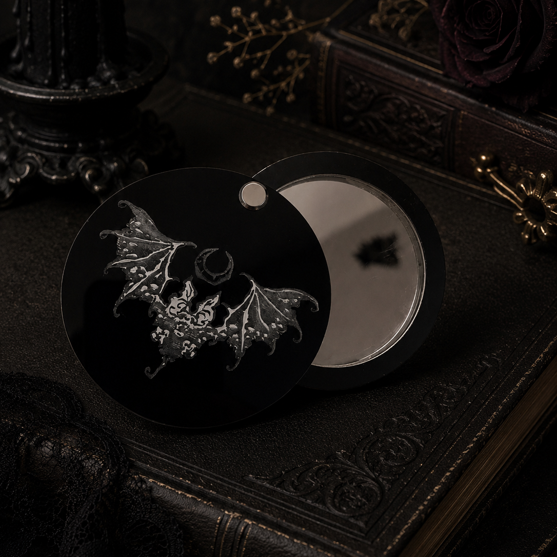 Open gothic bat pocket mirror showing the swivel lid and mirror inside with engraved black acrylic artwork.