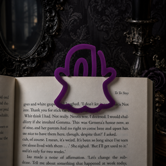 A purple acrylic bookmark shaped like a stylized hand holding an open book, set against a dark, ornate background.