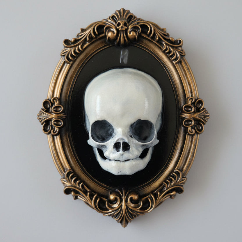 Gothic anatomical wall frame with ornate baroque detailing and pale fetus skull centrepiece