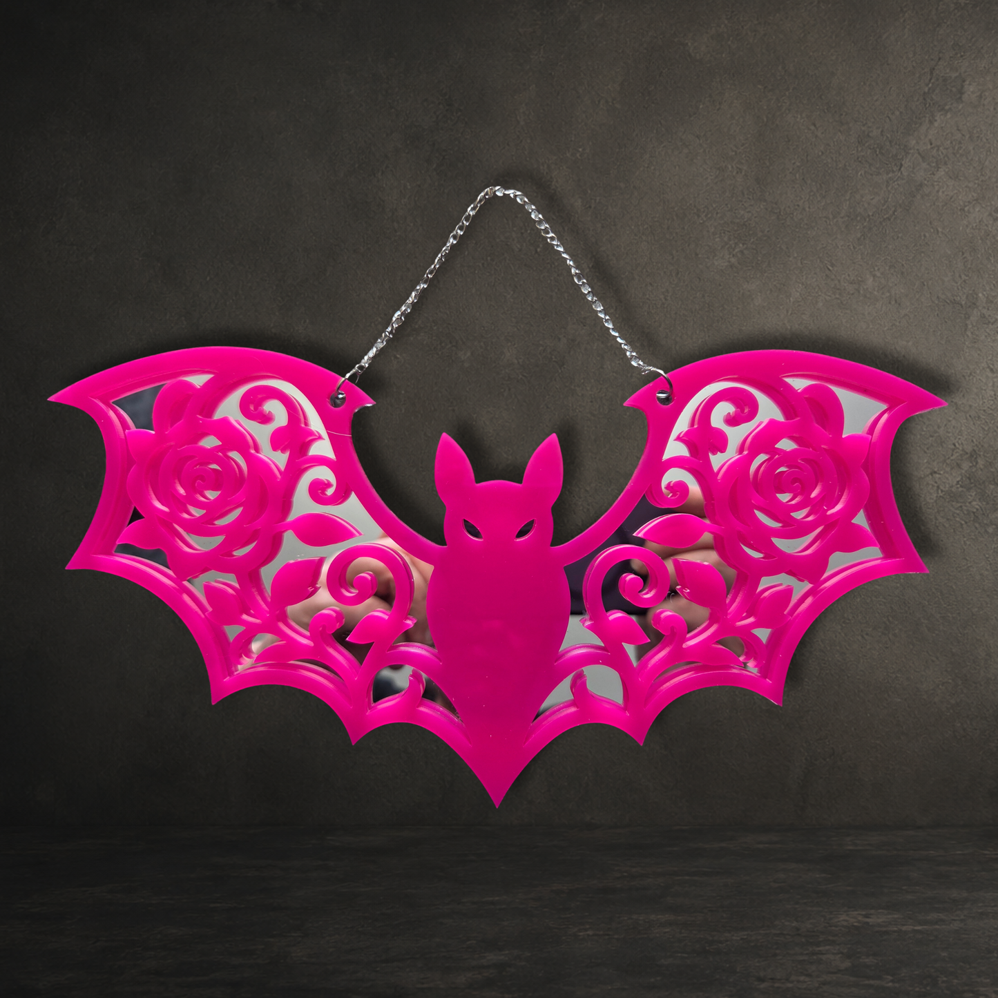 Hot pink gothic bat acrylic mirror with ornate rose wing pattern, supplied with a hanging chain.