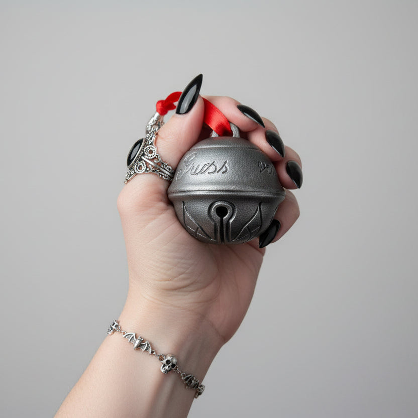 Krampus bell gothic Christmas decoration hanging with red ribbon in dark festive setting