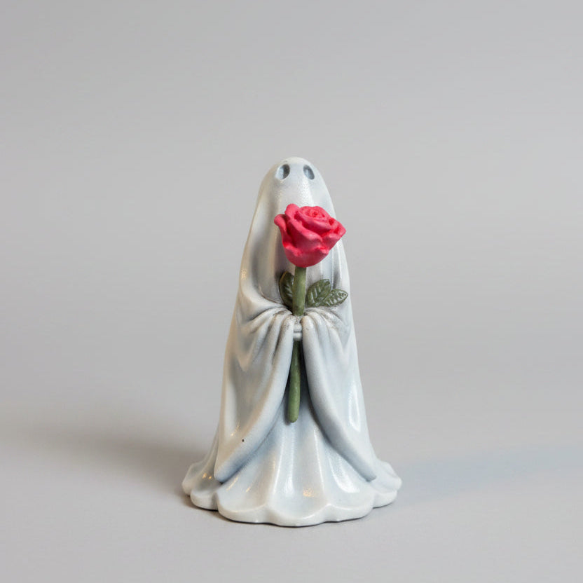 Cute gothic ghost ornament holding a pink flower for spooky shelf décor