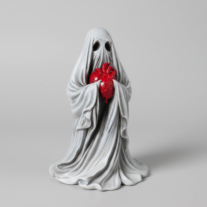 side view of the reliquary ghost figurine showing sculpted cloak folds and heart detail