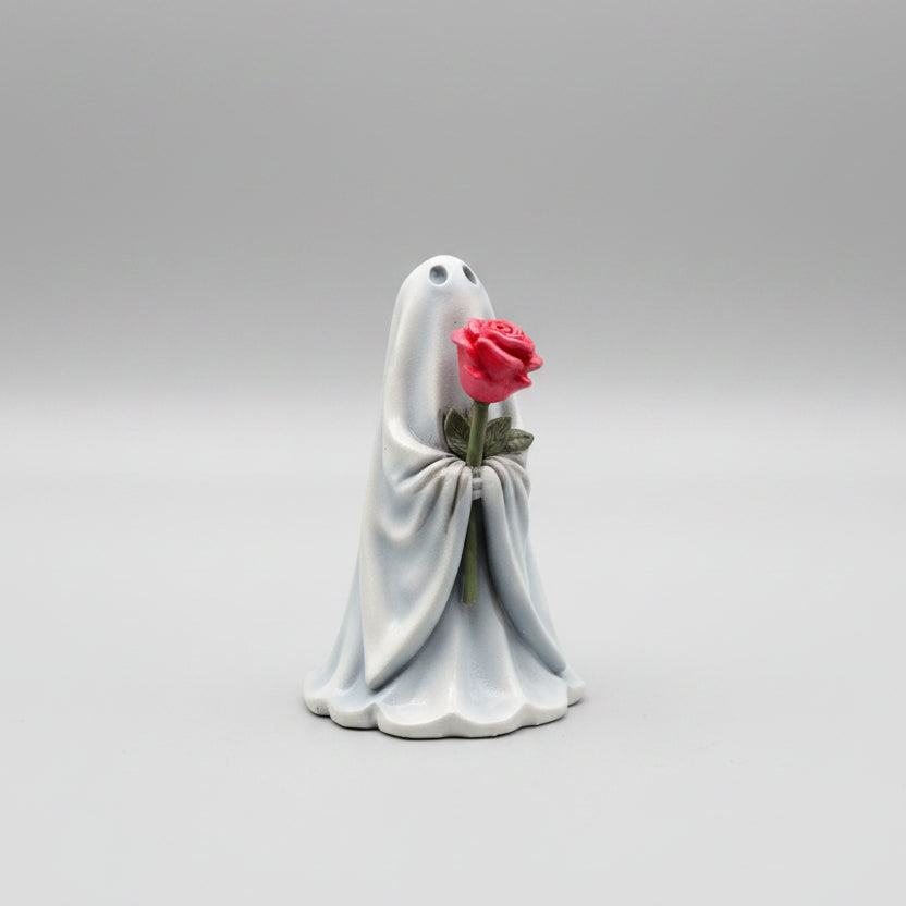 Close up of The Rosebearer ghost figurine with flowing white sheet and pink rose