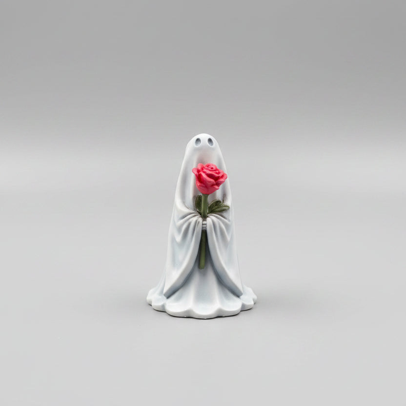 Hand painted gothic ghost figurine holding a bright pink rose on light background