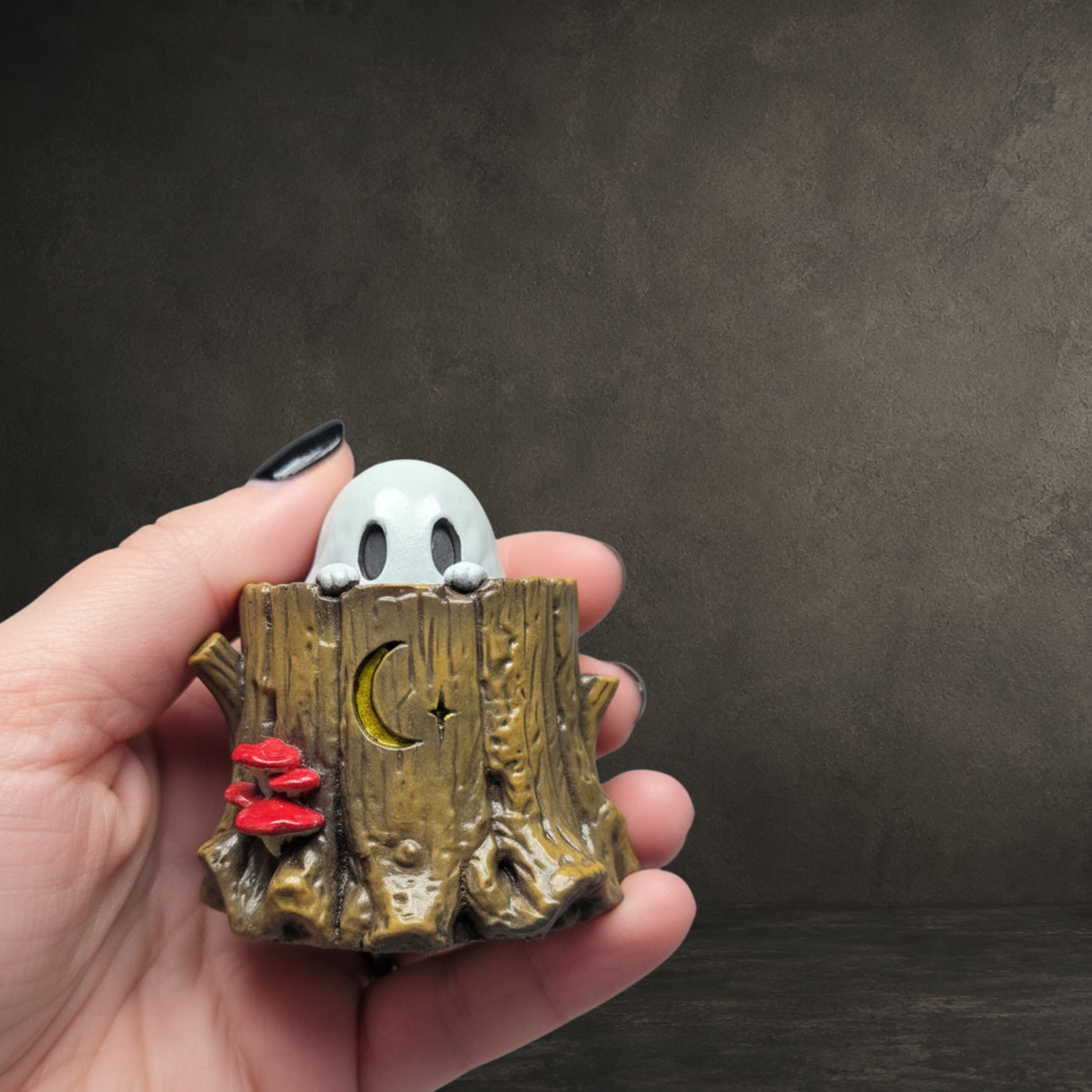 Small woodland ghost figurine standing inside a textured tree stump