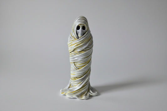 the wrapped one gothic ghost figurine tightly bound in layered shroud with hollow eyes